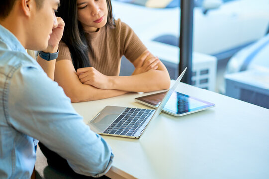 Asian casual businessman and woman try to join conference with laptop in co working space for meetign and working.