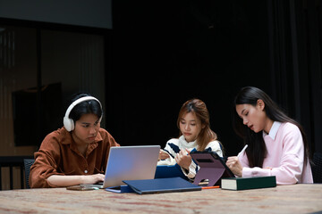 Student group concentration learning, reunion back to university   The male college student was rigorously studying online and two female friends were also engaged in reading.