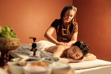 Obraz na płótnie Canvas Relaxation Asian woman customer get service skincare scrubbing massage with masseuse in cosmetology spa centre. Masseuse applying salt scrub on back customer in spa salon.