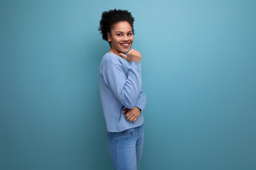 close-up of a young successful dark-skinned woman with puffy hair in blue clothes isolated...