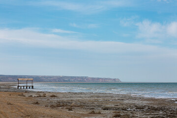 a blue sea and a dry mountain