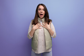 surprised young brunette woman on purple background
