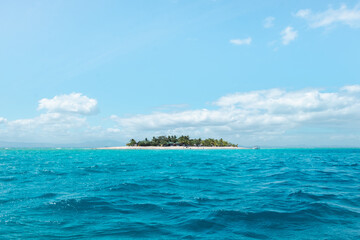 A small inhabited island surrounded by turquoise water on a sunny day, the perfect luxury holiday destination, Fiji