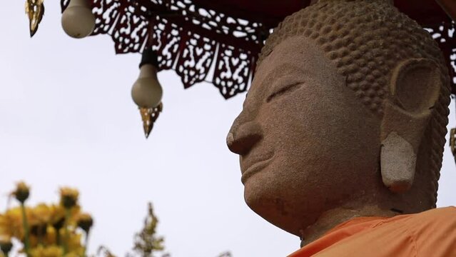 Close up of old sandstone Buddha statue located in middle of Phayao Lake. Wat Tilok Aram is landmark of Phayao lake, Thailand.
