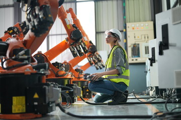 Fototapeta na wymiar Portrait of Female Automotive Industry 4.0 Engineer in Safety Uniform Using Laptop at Car Factory Facility. Assembly Plant. engineer working at automated AI robotic production factory..