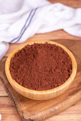 Cocoa powder on wood background. Cocoa powder in wooden bowl