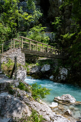 Beautiful, turquoise Soca river, passing under the old, wooden bridge, deep in the slovenian Alps mountains