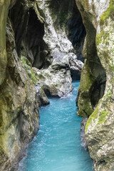 Fototapeta na wymiar Crystal clear Soca river, one of the most beautiful european rivers, deep in the rocky canyon of slovenian Alps
