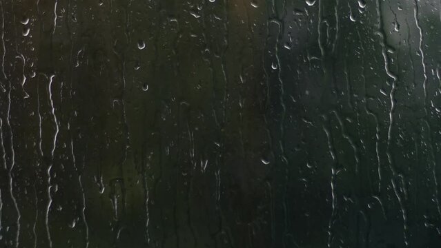 Raindrops on window on dreary rainy day