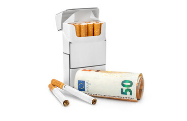 Opened pack of cigarettes with rolled money. Isolated on white.