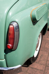 Rear light on pastel green retro car. Closeup.