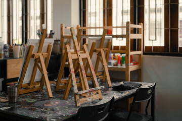 Interior of the creative art workshop with wooden easels and brushes and tools