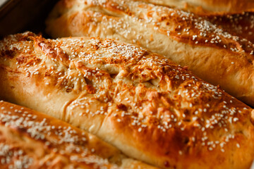 Close up shot homemade food baking concept. Fresh hot soft fluffy ginger golden brown sesame seeds buns pie bread dessert pastry in loaf pan. Bakery products, image with copy space.