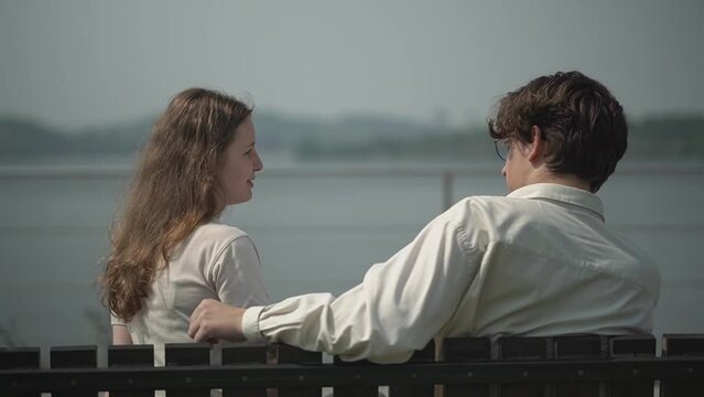 teenagers on a date sit on a bench. first relationship. teen date. High quality Full HD video recording