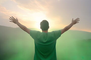 Fototapeta na wymiar Happy young man standing in a natural sunrise with raising arms