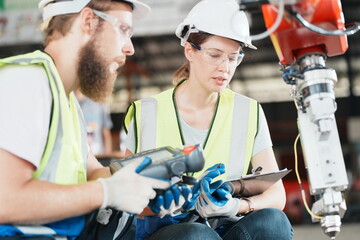 Industrial Engineer at work in factory, industrial engineers working at automated AI robotic production factory - New technology concept