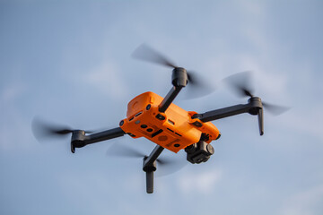 A small orange drone in the air.