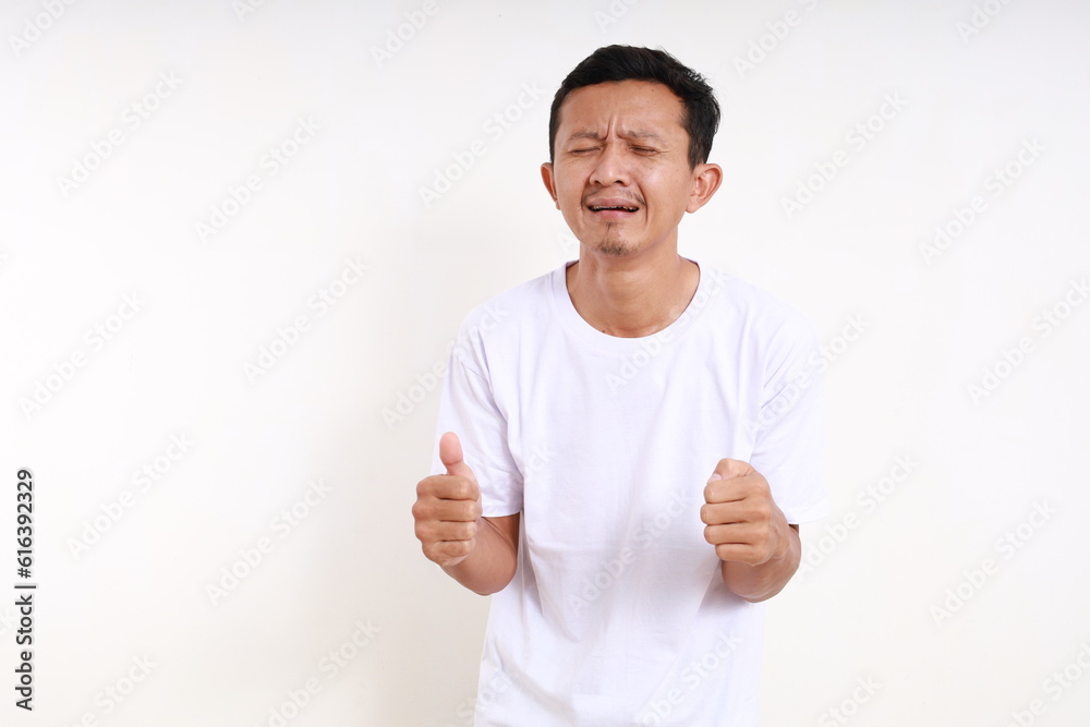 Wall mural Sad asian funny man crying against white background with copyspace