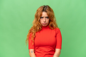 Young caucasian woman isolated on green screen chroma key background with sad expression
