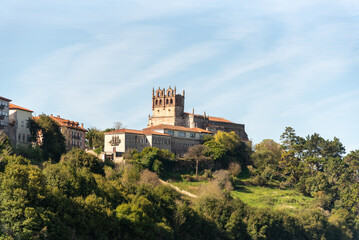 Fototapeta na wymiar Panoramic view of the medieval castle of San Vicente de la barquera. On the top of a hill surrounded by vegetation and next to the sea during a sunny summer day in cantabria.