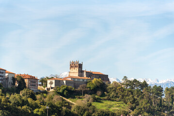 Fototapeta na wymiar Panoramic view of the medieval castle of the tourist village of San Vicente de la Barquera in Cantabria surrounded by an impressive natural landscape with the snow-capped Picos de Europa 