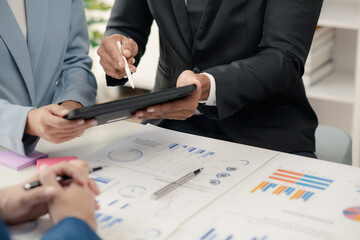 Group businessmen are reviewing monthly sales documents for analysis and marketing plans for more sales growth, they are the founders of young companies co-founding startups. Sales management concept.