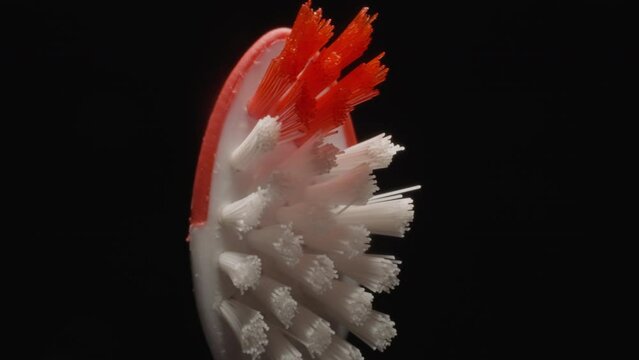 Hard bristles texture of small toothbrush for children on black background. Bright colourful brush for thorough cleaning teeth and cavity macro