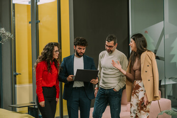 Gorgeous stylish brunette businesswoman talking to her junior colleagues while her middle-aged manager is listening to her. Collaboration concept