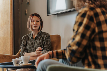 Portrait of female friends meeting in coffee shop and discussing news