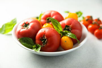 Fresh ripe tomatoes on a white plate