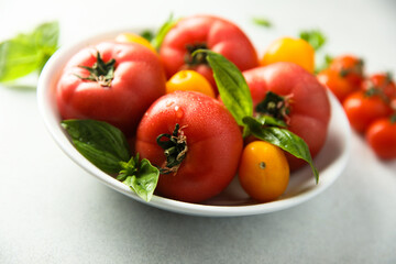 Fresh ripe tomatoes on a white plate