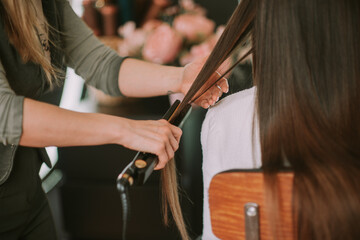 Combing hair. Ironing hair. Close up photo