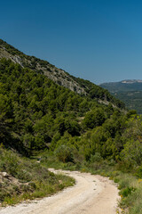 Fototapeta na wymiar Small gravel mountain road passing over a mountain range, Costa Blanca, Alicante, Spain