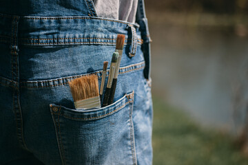 Close up of brushes in a jeans pocket