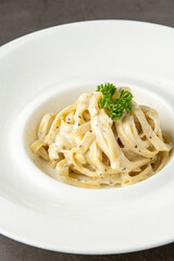 Freshly made fettucini alfredo on a white porcelain plate