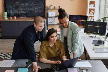 Portrait of all female business team working on It project together in office