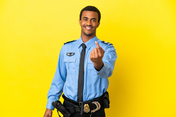 African American police man over isolated yellow background doing coming gesture