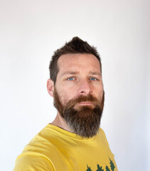 bearded man in yellow polo in white background