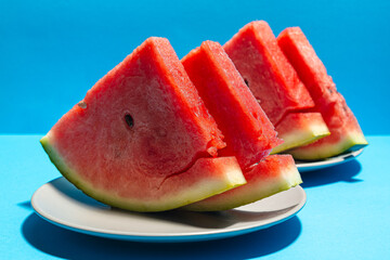 Front view of slices of watermelon on blue background