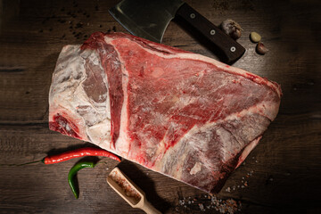 Organic machete or hanger butcher steak, near butcher knife with pink pepper and rosemary. Black...