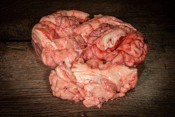 Pink brain raw before cooking on a wooden table. Raw fresh brain of a mammalian animal, a cow. Raw...