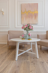 a close view of a tea table with two stylish armchairs in a modern cozy soft interior in warm delicate pastel pink and beige colors