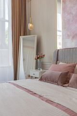 a close view of the bedroom in a modern cozy soft interior in warm delicate pastel pink and beige colors