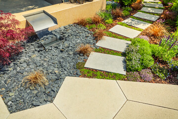 Detail of  garden path with stone slabs with bark mulch and native plants. Landscaping and...
