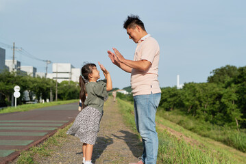 娘と手をたたいて遊んでいるお父さん