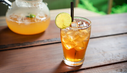 Refreshing with glass of Iced Tea add Lemon juice on wooden table mai tai