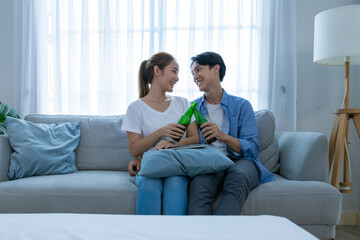 Obraz premium Young couple watching tv series laughing happily using tablet and sitting on sofa bed 