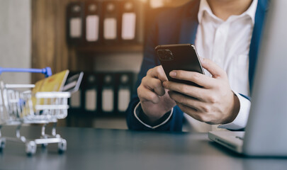 Businessman use credit card to shopping online in internet website shop with computer laptop on work table in office.