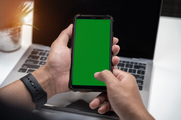 Man holding smartphone with blank screen, close-up of hands. Space for text.