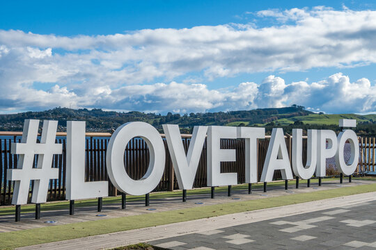 Hashtag Love Taupo sign in front of Lake Taupo in New Zealand.